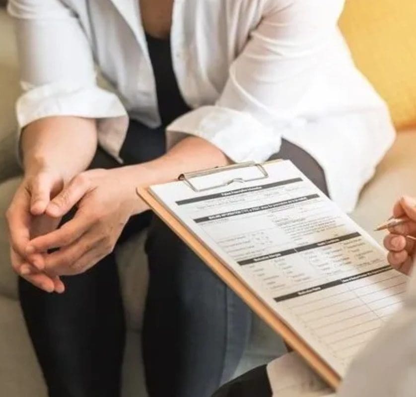 A Person Talking to a Doctor With a Clipboard